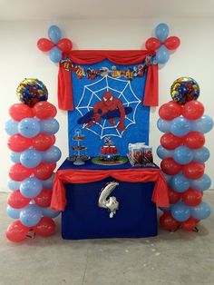 a birthday party setup with balloons and spiderman decorations on the table for an event