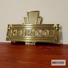 a gold sign that says restroom on it