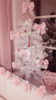 a white christmas tree decorated with pink bows