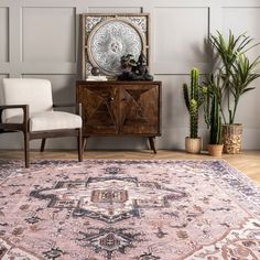 a living room area with a rug, chair and potted plants