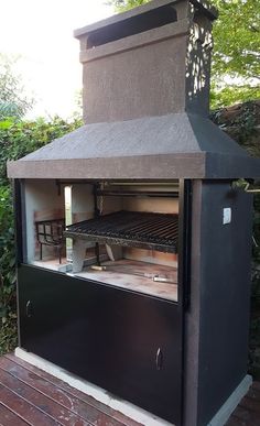 an outdoor bbq grill with two chairs on it