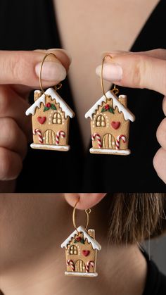 a woman is holding up two gingerbread house shaped earrings with candy canes on them