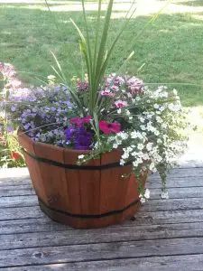 a wooden barrel filled with lots of flowers