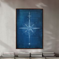 a blueprinted compass is hanging on the wall next to a bookcase with several books