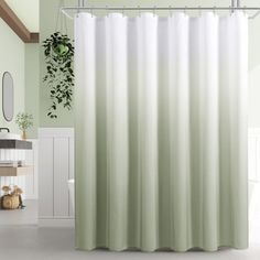 a white shower curtain in a bathroom with green walls and flooring, along with a potted plant on the wall