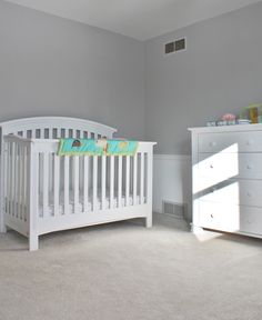 a baby's room with a white crib and dresser