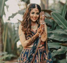 a woman is holding her hands up to show off her hendi and jewelry on her wedding day