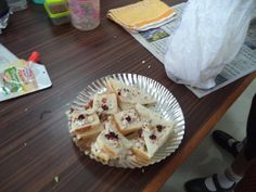 a plate full of food sitting on top of a wooden table next to plastic bags