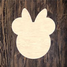 a wooden cutout of mickey mouse's ears on a wood background with planks