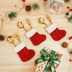 christmas decorations with gold forks and spoons on a table next to a gift bag