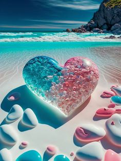 a heart shaped object sitting on top of a sandy beach