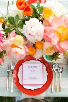 a red plate sitting on top of a table covered in flowers