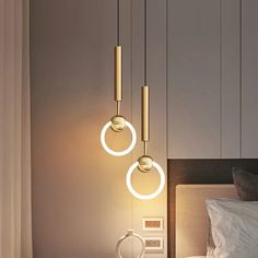 three lights hanging from the ceiling above a bed