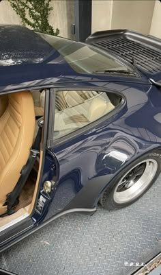 a blue sports car with its door open