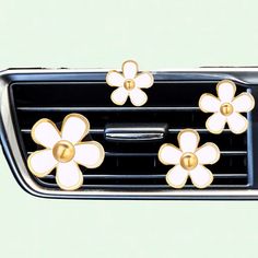 three flowers are attached to the front grille of a car's air freshener