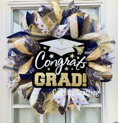 a graduation wreath with the words congrats grad hanging on it's front door