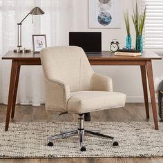 a white office chair sitting in front of a desk with a laptop computer on it