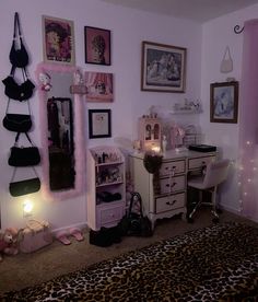 a bedroom decorated in pink and black with pictures on the wall, leopard print rug