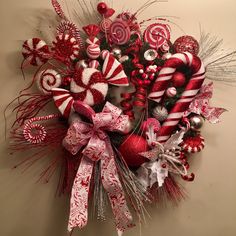 a christmas wreath with candy canes and other holiday decorations on it's side