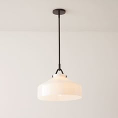 a white light hanging from a ceiling fixture in a room with no one around it