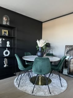 a dining room with black walls and green chairs