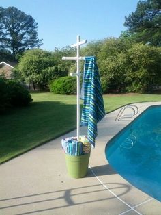 a towel rack next to a pool with a cross hanging from it's side