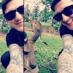 a man in sunglasses taking a selfie with a kangaroo