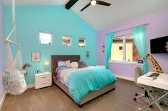 a bedroom with blue and purple walls, a bed in the middle and a desk on the other side