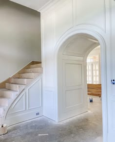 an empty room with white walls and stairs