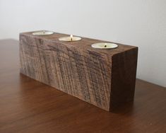 three candles are placed on a wooden block