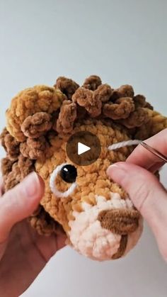 a person is holding a stuffed animal with scissors in their hands and threading it