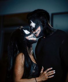 a man and woman dressed up as scary clowns kiss each other's cheek