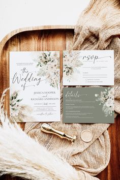 the wedding stationery is laid out on top of a wooden tray with furnishing