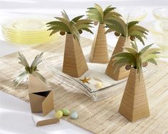 three wooden palm trees are sitting on a place mat with other items around the table