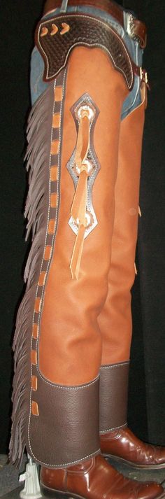 "These chaps are made with a high quality, russet brown chap leather. They have 8 oz. tooling leather trim pieces, dyed a dark brown color with a basket weave tooled stamp on them. They have 4\" Chocolate colored fringe on the leg, trimmed with russet lace. They have three metal barbed wire conchos on each leg as well. Each leg closes with a full length zipper. These chaps are durable yet supple making them a nice choice for work or show. Please message us for measurements when you order. Thanks Shotgun Chaps, Western Chaps, Riding Chaps, Leather Craft Patterns, Little Cowboy, New R, Leather Car Seats, Mens Gear, Chocolate Color