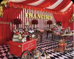 a red and white checkered floor with lots of food on top of the table