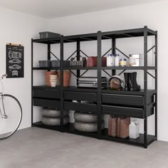 a bike is parked in front of a black shelf with baskets and other items on it