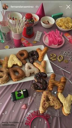 a table topped with lots of donuts and desserts