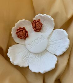 two white and brown flowers on top of a yellow cloth with the word love written in it