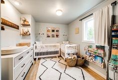 a baby's room with two cribs and lots of toys