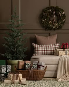 a living room filled with christmas presents under a wreath on the wall next to a couch