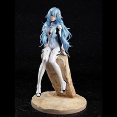 a figurine sitting on top of a rock with blue hair and white skin