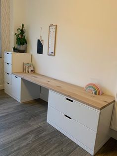 a desk with two drawers and a clock on the wall