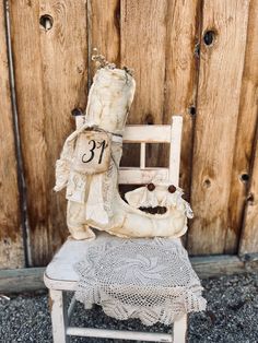 an old chair with a stuffed animal sitting on it's back next to a wooden fence