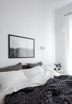 a bedroom with white walls and black bedding