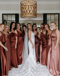 a group of women standing next to each other in front of a chandelier