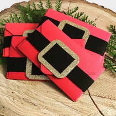 some red and black paper with gold glitters on it sitting on a tree stump