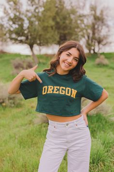 a woman in a green shirt is posing for the camera