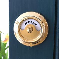 a close up of a blue door with a gold handle and a white sign that says vacany on it