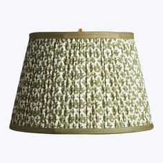 a green and white lampshade with an intricate pattern on it's fabric